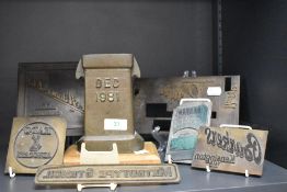 A cast metal receptical, marked Dec 1981, and mounted on a wooden plinth, together with a collection