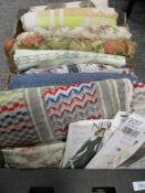A box of mixed vintage and retro fabrics, a vintage towel and a selection of dress patterns.