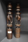 Two turned African hard wood candlesticks, having carved elephants to centres.