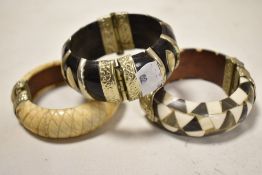 Three decorative Eastern bangles with white metal mounts