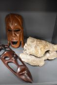 Two wooden tribal masks and a pottery shell study.