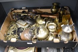 A box full of vintage brass and copper ware, including horse head stirrup cups, horse brasses,