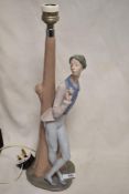 A Nao by Lladro lamp base of a Romeo style lover with rose leaning against a tree, 45cm tall.