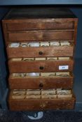An early 20th century pine cabinet, housing a large collection of optometrists glass lenses.
