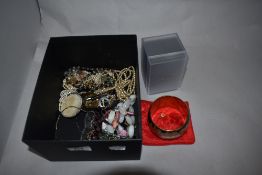 An assorted collection of costume jewellery, a wide brass metal bangle, and a DKNY ladies