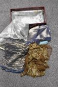 A shoe box containing an assortment of vintage fabrics and sections, including metallic thread