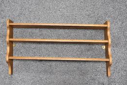 An oak open backed three tiered hanging shelf rack, measuring 38cm tall and 68cm long