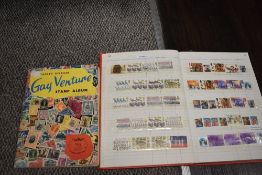 A Stanley Gibbons Gay Venture stamp album containing assorted stamps & an album of commemorative,