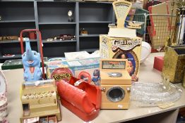 A vintage boxed Girl's World make-up and hair styling model, a Casdon toy washing machine, scales,