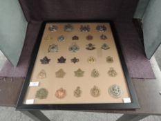 A framed display of twenty eight Canadian Military Cap Badges including Toronto Scottish, 1st