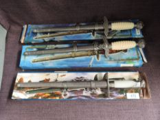 Three modern reproduction German WWII Daggers with scabbards in card boxes