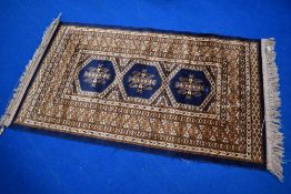 A decorative rug, labelled 100% Viscose, with hanging rail