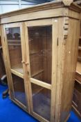 A rustic pine glazed cabinet , width approx. 130cm, height 180cm