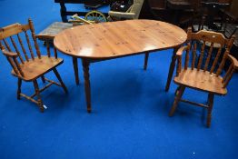 A modern pine dining table with two chairs.