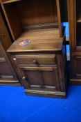 A modern Ercol mid stain narrow shelf with cupboard under