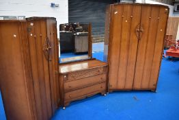 A mid 20th century oak three-piece 'Austinsuite' bedroom suite, comprising large double door
