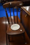A traditional stained frame child's commode chair with enamel dish