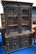An 18th Century oak bookcase having carved and applique decoration with lion mask and green man ,