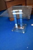 A modern glass topped dining table with chrome base