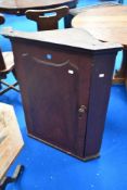 An early 20th century pine corner cupboard with a scumble paint finish.