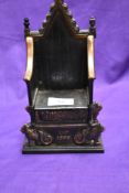 A cast metal penny bank modelled as Regal throne, EIIR, incised mark to reverse 'Harper'