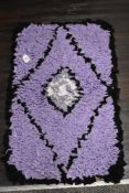 An as new, handmade peggy/ proddy rug in purple, black and white.
