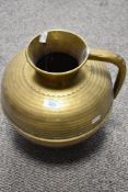 A 20th century large brass jug/ receptacle with handle, having embossed detailing.
