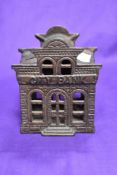 A novelty cast metal penny bank, modelled as city bank