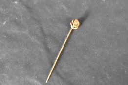 A yellow metal pin stamped 15ct having a diamond chip with starburst mount, approx 1.6g