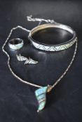 A silver and faux opal four piece jewellery suite comprising of pendant, earrings, ring and