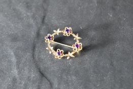 A 9ct gold garland brooch having amethyst set floral decoration, approx 3.9g