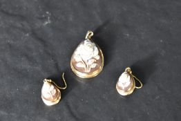 A conch shell cameo pendant with matching earrings having rose design in yellow mwetal mounts