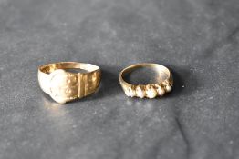 A seed pearl ring having five small pearls in a gallery style mount on a yellow metal loop, size L &