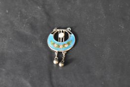 A silver and enamel pendant by Charles Horner, Chester having floral decoration and silver bead