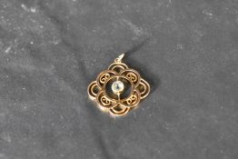 A small yellow metal, presumed gold Edwardian style pendant having a central pale blue paste stone