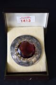 A large silver Scottish style brooch with central amethyst style paste stone, diameter approx 64mm