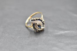 A sapphire and diamond open swirl cluster in a claw set basket mount on a 9ct gold loop, size Q &