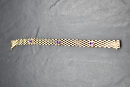 A 9ct gold brick link bracelet having three inset amethysts and a slide clasp, approx 185mm & 10.4g