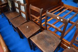 A set of four Georgian oak solid seat dining chairs