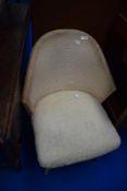 A vintage woven fibre nursing chair on dansette style legs