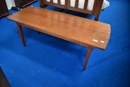 A 1970's mahogany coffee table, of oblong form with bowed ends and tapering square section legs,