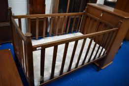 An early 20th Century oak Arts and Crafts cot, believed to be Liberty, bearing label W & S patent,