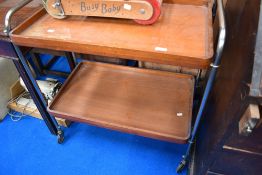 A vintage tea trolley having chrome frame and mahogany trays