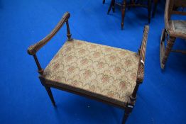 A Regency style dressing table stool having scroll arm and fluted legs