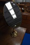 A vintage toilet mirror having brass frame and stand