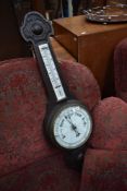 A traditional aneroid barometer , with thermometer scale