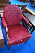 A Victorian mahogany easy chair having later burgundy upholstery and scroll arms