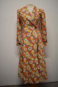 A 1930s floral cotton house coat, having notched collar, long sleeves and button fastening.