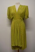 An early 1930s mustard novelty print yellow day dress, having smocking to shoulders, smocked apron