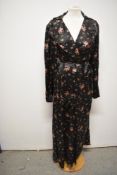 A late 1930s/1940s glossy black rayon house coat, having bright floral sprigs, pocket and dramatic